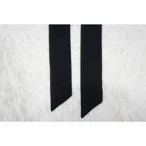 Dettaglio dei lacci in chiffon nero per top estivo con maniche a pipistrello.