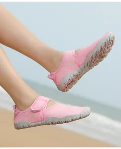 Pink breathable water shoes for women with non-slip sole and Velcro strap on beach.