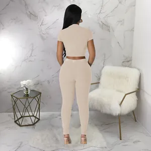 Back view of a women's beige two-piece ribbed sports set with crop top and leggings