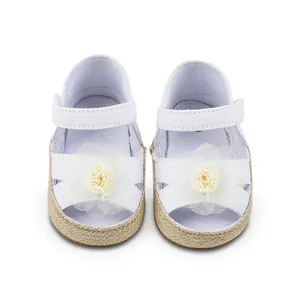 Vista superior detallada de zapatos blancos para caminar de bebé con flores de tela