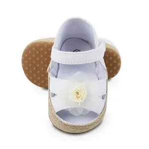 Nahaufnahme weißer Lauflernschuhe für Mädchen mit weicher Sohle und Blume