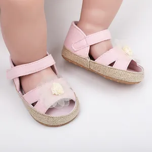 Primer plano de zapatos rosas de bebé con una flor decorativa y suela de tejido suave y flexible