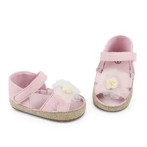 Detalle de zapatos princesa rosa para bebé con adorno de flor de encaje
