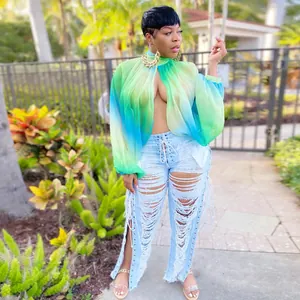 Modella indossa una vivace camicetta di chiffon sfumata verde e blu con maniche a pipistrello