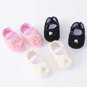 Detailed view of baby soft sole pre-walker shoes in pink, black, and cream colors