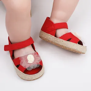 Primer plano de zapato de princesa rojo para bebé con flor de tul blanco y suela tejida