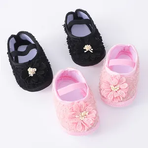 Detailed macro view showing the soft fabric texture and floral decoration of baby shoes