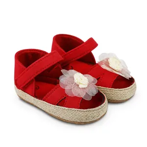 Vista detallada de zapatos de princesa rojos para bebé con flor y suela de paja trenzada