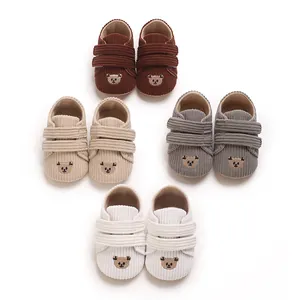 Détail de chaussures de bébé en velours côtelé en quatre couleurs avec broderie ours