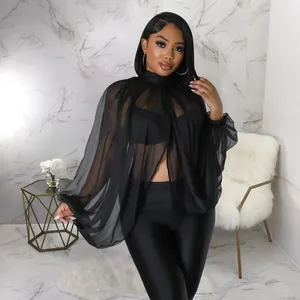 Dettaglio della camicia in chiffon nero trasparente con maniche a pipistrello eleganti