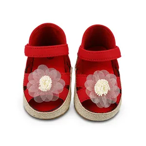 Vista detallada de zapatos rojos de princesa para bebé con flor de encaje y suela tejida