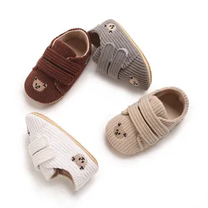Détail de chaussures pour bébé en velours côtelé en quatre couleurs avec broderie ours