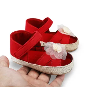 Primer plano de zapatos rojos de princesa para bebé niña con suela blanda y detalle flor.