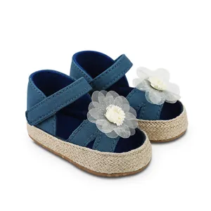 Primer plano de zapatos azul marino para bebé con flores blancas y suela blanda tejida