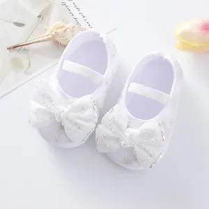 Elegant white baby princess shoes featuring large rhinestone-studded bows and soft soles.