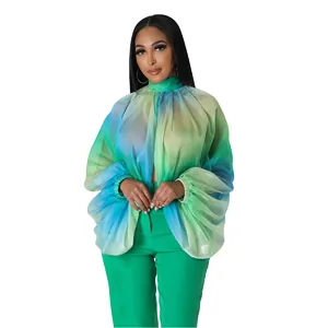 Dettaglio elegante di camicetta in chiffon sfumato blu verde con maniche a pipistrello