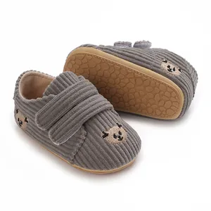 Vue détaillée de chaussures bébé gris en velours avec semelle antidérapante