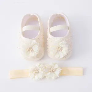 Detail of cream baby shoes and floral headband set with delicate fabric flowers