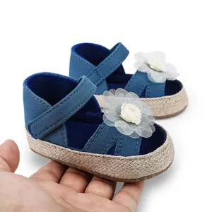 Detalle de zapatos azules para bebé niña con flor de encaje y suela blanda tejida