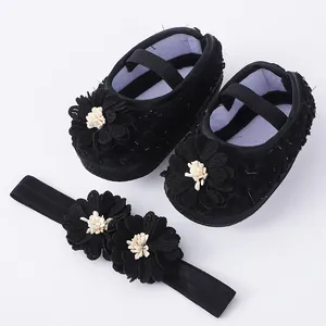 Adorable black baby flower shoes and headband set with soft soles for newborns.