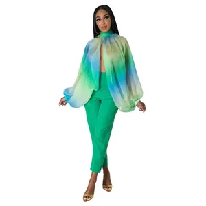 Dettaglio di donna che indossa una blusa in chiffon verde sfumato con maniche a palloncino.