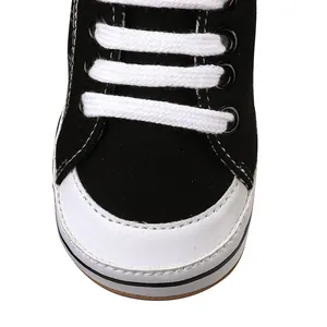 Gedetailleerde weergave van zwarte canvas babyschoenen met stiksels