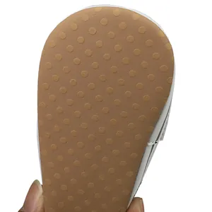 Detailopname van de antislipzool van een babyschoentje met bruin stippenpatroon