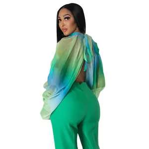 Vista posteriore di una camicetta in chiffon sfumato verde con scollo a fiocco e pantaloni