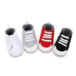 Detailweergave van baby canvas schoentjes in de kleuren wit, grijs, rood en zwart.