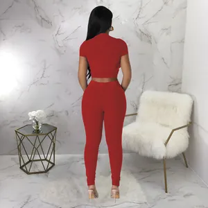 Back view of a red ribbed two-piece set featuring a short sleeve crop top and leggings.