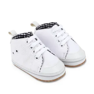 Close-up van witte canvas baby loopschoentjes met geruite voering voor baby's van 0-1 jaar oud