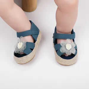 Detailaufnahme von blauen Babyschuhen mit weißer Blume und weicher geflochtener Sohle