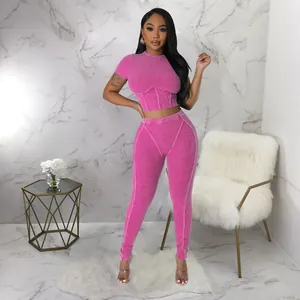 Chic pink ribbed two-piece athletic set with short sleeve crop top and matching leggings.