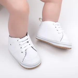 Detailopname van witte canvas baby loopschoentjes met zachte zolen en vetersluiting