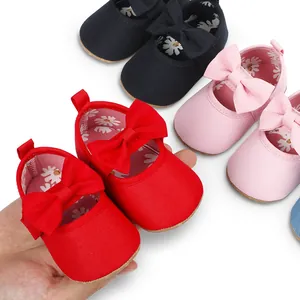 Primer plano de zapatos de princesa rojos para bebé con lazo y forro de flores