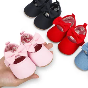 Primer plano de zapatos de princesa para bebé con lazos, en varios colores en la mano.