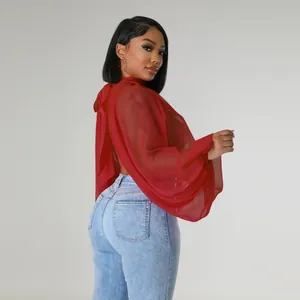Dettaglio di una camicetta rossa in chiffon trasparente con eleganti maniche a pipistrello