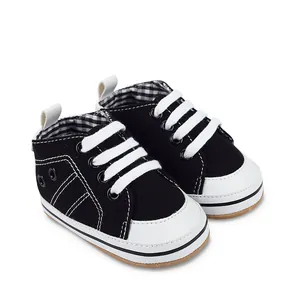 Gedetailleerd overzicht zwart-witte canvas baby loopschoenen met witte veters