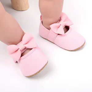 Primer plano de zapatos de princesa rosas para bebé con suelas blandas y lazos decorativos