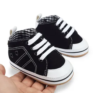 Gedetailleerde weergave van zwarte canvas babyloopschoenen in de hand om de maat te tonen.