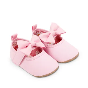 Vista detallada de zapatos de princesa rosa para bebé con lazos grandes y suela