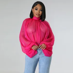 Dettaglio della camicia in chiffon rosa trasparente con scenografiche maniche a pipistrello