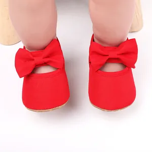 Vista detallada de zapatos de princesa rojos para bebé con lazos grandes y suela suave