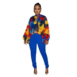 Dettaglio di una blusa in chiffon con stampa astratta colorata e maniche a pipistrello