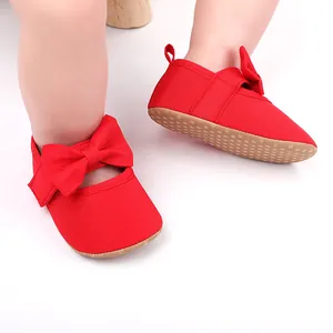 Primer plano de zapatos de princesa rojos para bebé con lazo y suela suave antideslizante.