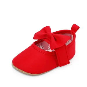 Primer plano de zapato de princesa rojo para bebé con lazo grande y suela blanda.