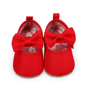 Vista superior de zapatos rojos de princesa para bebé con un lazo grande y forro floral