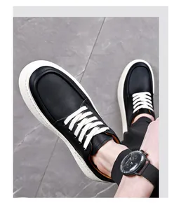 Macro view of black leather men's casual sneakers featuring thick white soles and laces