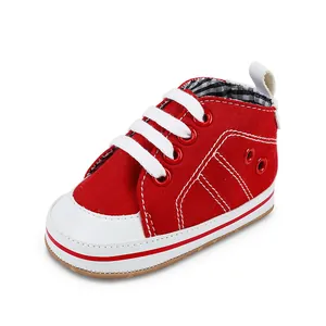 Gedetailleerde opname van rode canvas baby loopschoen met witte veters en zachte zool