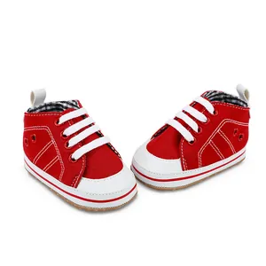 Gedetailleerde weergave van rode canvas babyschoentjes met witte veters en witte zolen